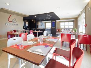 a restaurant with wooden tables and red chairs at Campanile Marne la Vallée - Chelles in Chelles