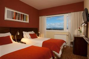 a hotel room with two beds and a window at Hotel Las Lengas in Ushuaia