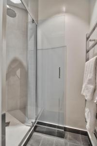 a shower with a glass door in a bathroom at Rue du Louvre - Luxury apartment in Paris