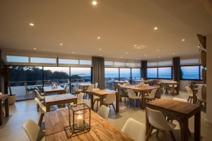 a restaurant with tables and chairs and large windows at Casa Victoria Suites in Sant Josep de sa Talaia