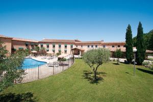 un gran edificio con piscina y patio en Logis Hôtel Le Mas De Jossyl, en La Roque-d'Anthéron