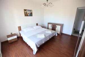 a bedroom with a white bed and wooden floors at Apartment Marin in Donji Seget
