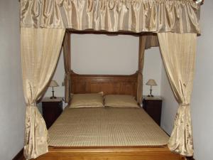 um quarto com uma cama de dossel e cortinas em Casa Do Brasao em Tabuaço