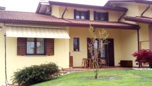 a yellow house with a small tree in the yard at Mon Refuge Villa Deluxe in Correzzola