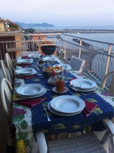 una mesa con platos de comida en el balcón en Sea front attic, en Chiavari