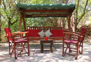 a wooden bench with two chairs and a table at Aeriko Benovias Rooms & Apartments in Karfas