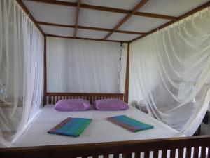 a bed with two pillows and two towels on it at Villa Sunrise in Tangalle