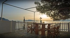 una mesa y sillas con el océano en el fondo en Seasidehouse, en Hydra 6 fotos más