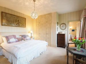 a bedroom with a bed and a vase of flowers on a table at The Clock Tower in Daventry