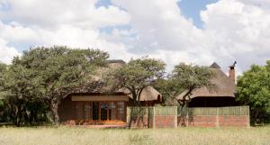 una casa con techo de paja en un campo en Dronfield Reserve en Kimberley