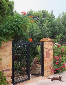 a black gate with a cat sitting in front of it at Efta Anemi - Benovias in Karfas