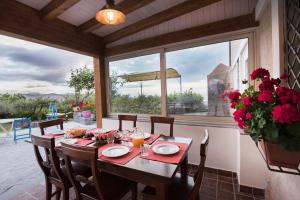 a dining room with a table and a large window at Seacily Etna House in Piedimonte Etneo