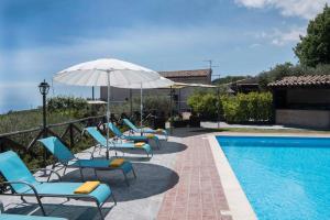 een groep stoelen en een parasol naast een zwembad bij Seacily Etna House in Piedimonte Etneo