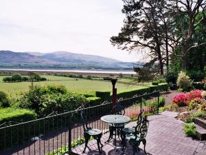 un patio con una mesa y 2 sillas y una valla en Gogarth hall Farm holidays, en Pennal 5 fotos más