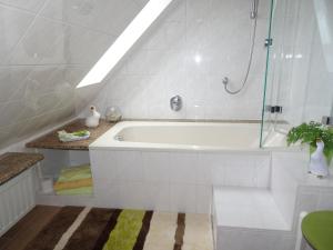 Ferienwohnung Panorama في Rauenstein: حمام أبيض مع حوض استحمام ودش