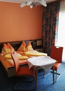 バート・クラインキルヒハイムにあるAppartement Riaのテーブルと椅子が備わる客室のベッド1台分です。