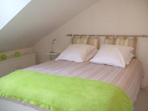 a bedroom with a bed with green sheets and pillows at Appartements Les remparts d'Alienor in Poitiers