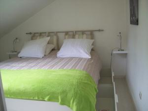uma cama com lençóis e almofadas verdes num quarto em Appartements Les remparts d'Alienor em Poitiers
