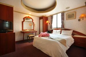 Habitación de hotel con cama y espejo en Wang Fu Hotel en Miaoli