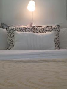 Una cama con almohadas y una lámpara encima. en Paris Lady Mimi en París