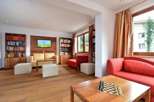 a living room with a red couch and a table at Gasthof Skirast in Kirchberg in Tirol