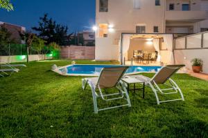 a yard with chairs and a swimming pool at night at Dream Villa in Kambánion