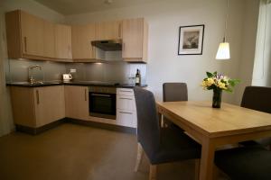 a kitchen with a wooden table with a vase of flowers on it at Apartment Marciana in Piran