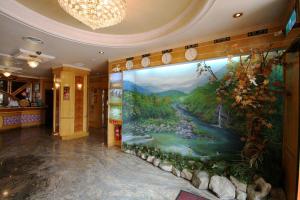 a large painting on the wall in a hallway at Wang Fu Hotel in Miaoli