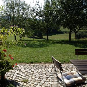 a park bench sitting next to a field with trees at Ferienwohnung Familie Kitzke in Teisnach
