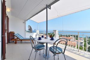 a table and chairs on a balcony with a view of the ocean at Apartment ANGIE - Marjan Hill in Split