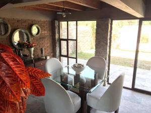 a dining room with a glass table and white chairs at Casa Ndomi in Valle de Bravo