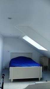 a white bedroom with a bed with a blue blanket at Gîte de Blessy in Blessy