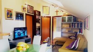 ein Wohnzimmer mit einem Sofa und einem TV in der Unterkunft Apartment Aldo in Omiš