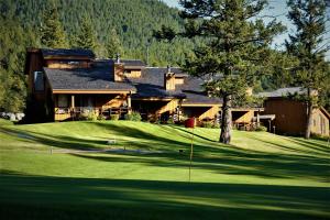 a house on a golf course with a putting green at Fairmont Villas Mountainside in Fairmont Hot Springs
