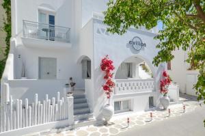 a white building with white stairs and flowers in white vases at Naxos Evilion Luxury Apartments & Suites in Naxos Chora