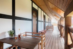a wooden table and benches on a wooden deck at Kwatery Prywatne Dzika Roza in Darłowo