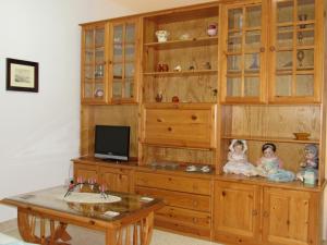 a large wooden cabinet with two dolls sitting on it at Central Studio Apartment in Santa Venera