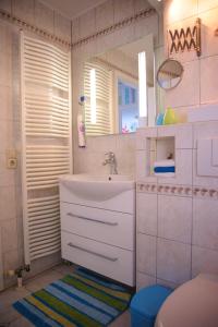 a white bathroom with a sink and a mirror at Ferienwohnung Kessler in Rust +5 photos