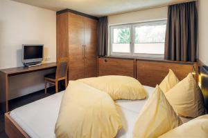 ein Hotelzimmer mit 2 Betten und einem Schreibtisch in der Unterkunft Appart Collina in Pfunds