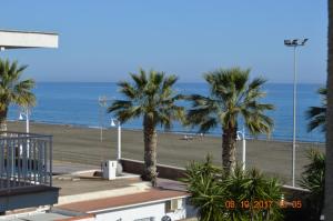 een uitzicht op een strand met palmbomen en de oceaan bij WintowinRentals La Posada del Mar in Rincón de la Victoria