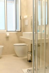 bagno bianco con servizi igienici e lavandino di Hotel Monaco a Caorle