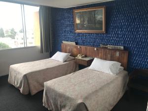 מיטה או מיטות בחדר ב-Hotel Savoy Inn