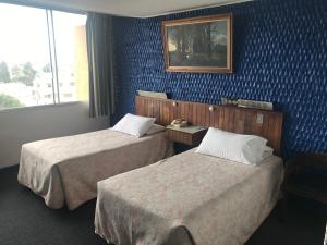 Postel nebo postele na pokoji v ubytování Hotel Savoy Inn