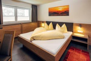 a bedroom with a large bed with yellow pillows at Appart Collina in Pfunds