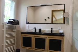 a bathroom with a sink and a mirror at La Garde Pile de Fichou in Bajamont