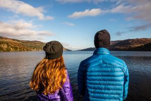 two men standing next to each other near a body of water at Morag's Lodge in Fort Augustus