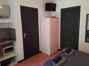 a bedroom with two black doors and a white refrigerator at A CASA DI L'ALIVU in Patrimonio