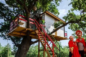 two people standing in front of a tree house at Casa sull'Albero in Lentella
