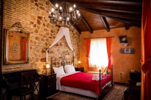 Un dormitorio con una cama con sábanas rojas y una pared de piedra. en Acronafplia Pension A, en Nauplia