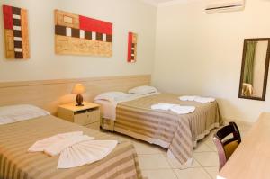 a hotel room with two beds and a mirror at Villa de Holanda Parque Hotel in Holambra +64 photos